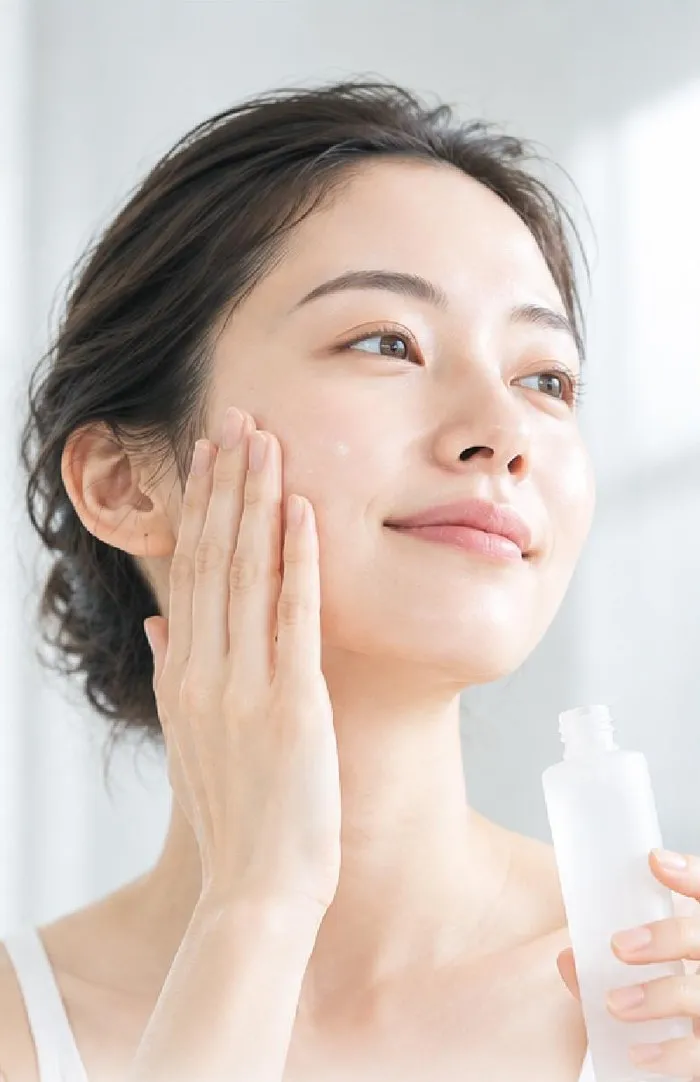 洗顔のあと化粧水をつける女性