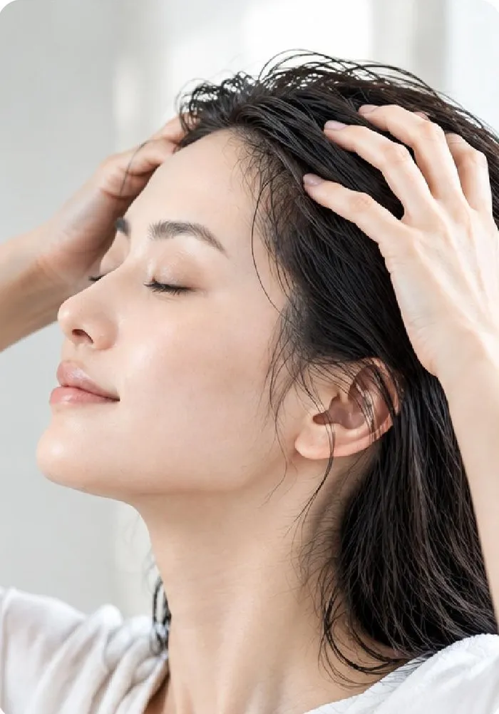 指の腹で頭皮全体になじませる女性